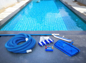 Swimmingpool Reinigungs Equipment liegt neben Pool