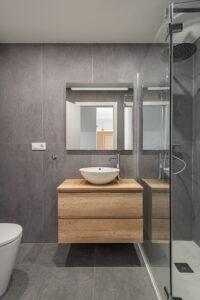 Stilvolles Badezimmerinterieur mit Arbeitsplatte, Spiegel und Dusche, minimalistischer Stil