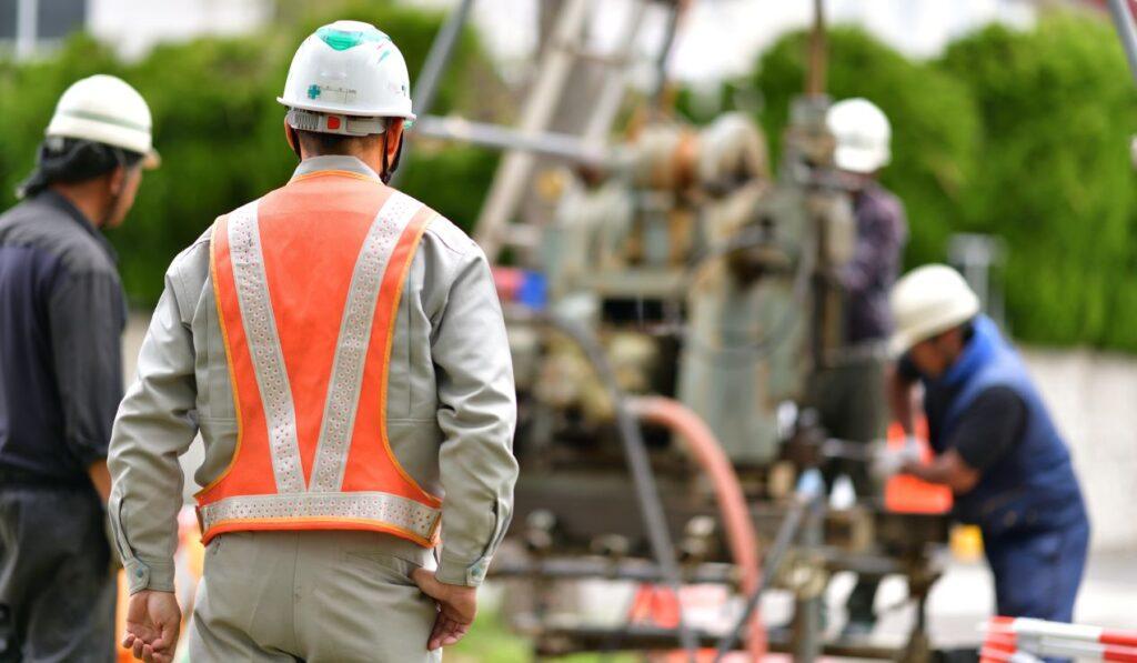 Facharbeiter bei Arbeiten an unterirdischer Infrastruktur, symbolisch fuer den Bau und Betrieb von Stauraumkanal-Systemen in urbanen Raeumen
