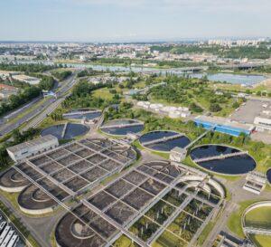 Luftaufnahme einer Klaeranlage im Stadtgebiet, stellvertretend fuer die wachsende Bedeutung moderner Loesungen wie dem Stauraumkanal bei Starkregen