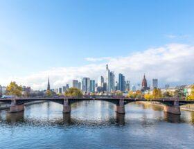 Skyline einer deutschen Grossstadt mit Fluss und Bruecke, symbolisch fuer urbane Wasserwirtschaft und die Rolle des Stauraumkanals bei der Stadtplanung