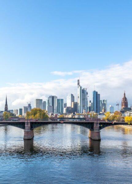 Skyline einer deutschen Grossstadt mit Fluss und Bruecke, symbolisch fuer urbane Wasserwirtschaft und die Rolle des Stauraumkanals bei der Stadtplanung