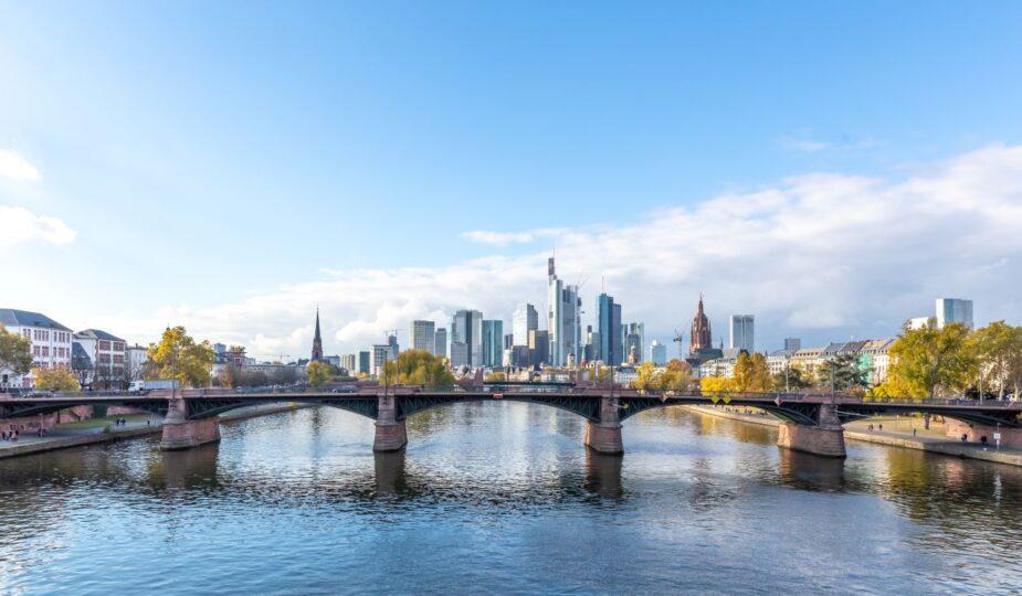 Skyline einer deutschen Grossstadt mit Fluss und Bruecke, symbolisch fuer urbane Wasserwirtschaft und die Rolle des Stauraumkanals bei der Stadtplanung